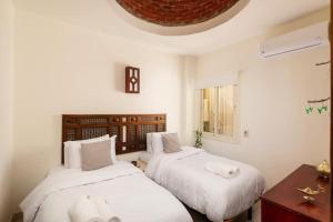 Makadi Heights Elite Residence - Hurghada, Red Sea في الغردقة: غرفة نوم بسريرين مع وسائد بيضاء