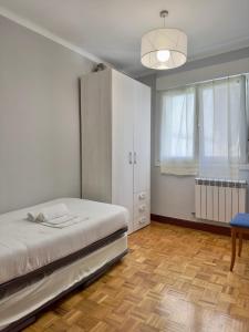 1 dormitorio con 1 cama y armario blanco en Lekeitio! Céntrico y con parking, en Lekeitio