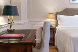 um quarto de hotel com uma cama e uma secretária com um candeeiro em King George, a Luxury Collection Hotel, Athens em Atenas