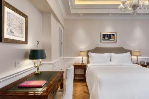 a bedroom with a bed and a table with a lamp at King George, a Luxury Collection Hotel, Athens in Athens