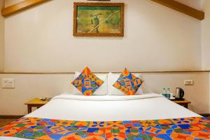 a bedroom with a bed and a picture on the wall at FabHotel Lotus Resort in Aurangabad