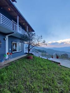 a house with a yard with a view of the mountains at Casa Letibunga in Mukteswar