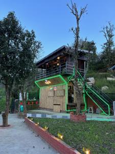 a building with a green staircase in front of it at Casa Letibunga in Mukteswar