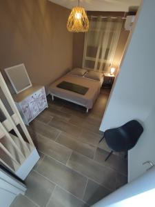 een slaapkamer met een bed en een stoel bij T3 ISIS APPART - Quartier Hauts Vallons in Mamoudzou