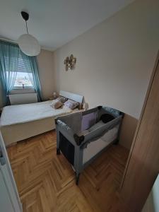 małą sypialnię z łóżkiem i drewnianą podłogą w obiekcie Krstić_lux apartman w mieście Subotica