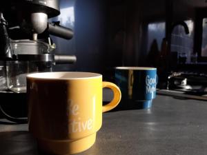 L'Estive في Croixanvec: كوبين قهوة يجلسون على منضدة في مطبخ