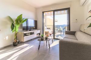 sala de estar con sofá y TV en SELECT' - T2 avec vue - Piscine et parking privé - CAPNAT-B08, en Bormes-les-Mimosas