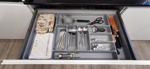 un cajón lleno de utensilios de cocina en un cajón en Piso de lujo 2 habitaciones, en Las Rozas de Madrid