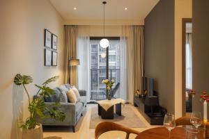 a living room with a couch and a tv at The MARQ Elite Apartel District 1 HCMC by SSens in Ho Chi Minh City