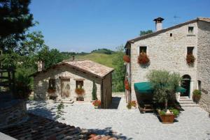 a large stone building with a house and a patio at Marzanella in Tredozio