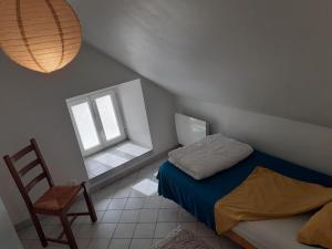 L'Estive في Croixanvec: غرفة نوم صغيرة بها سرير وكرسي
