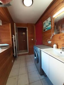 een badkamer met een wasmachine en een wastafel bij L'Estive in Croixanvec