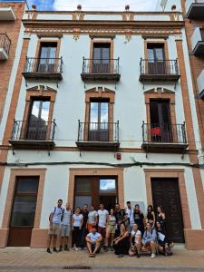 un grupo de personas de pie en frente de un edificio en Apartamentos Costa de la Luz Béjar 28-30, en Huelva