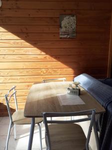 uma mesa e cadeiras num quarto com uma parede de madeira em L'Estive em Croixanvec