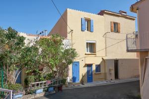 un bâtiment avec une porte bleue dans une rue dans l'établissement Le Belvèze, Emplacement central et calme, à Port-Vendres