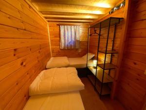 una camera con due letti in una cabina di legno di Chalet 't Musje a Durbuy
