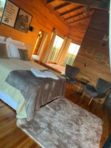 a bedroom with a bed and a desk and chairs at Pousada Querência Tarumã in São Joaquim