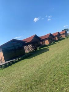 a row of houses with a green field in front at Pousada Querência Tarumã in São Joaquim