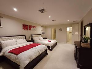 ein großes Schlafzimmer mit 2 Betten und einem Spiegel in der Unterkunft Perth 2-Story, Views, BBQ & More in Perth