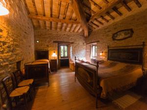 a bedroom with two beds and a stone wall at Marzanella in Tredozio