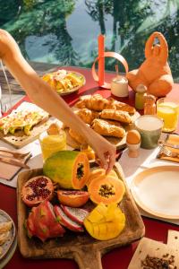 a table with a tray of food with a person cutting food at Le Martin Boutique Hôtel in Saint Martin