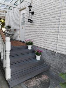 a wooden porch with two potted plants on it at Kaliininkuja in Lapua