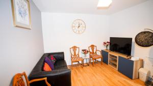 a living room with a couch and a tv at 4 Bed Spacious House Free Parking in Slough