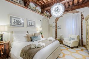 a bedroom with a large bed and a chair at Lucca Heritage Retreat in Lucca
