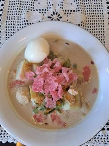 a bowl of soup with a dollop of food in it at Guguak Puro Guest House in Padangpanjang