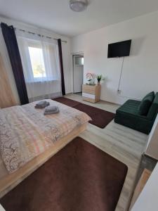 a bedroom with a bed and a green couch at Casa DARYA-24h Check-in in Bucharest