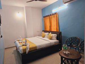 1 dormitorio con 1 cama y 1 mesa con sillas en Hotel Sea Rock, en Puri
