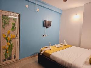 1 dormitorio con cama y pared azul en Hotel Sea Rock, en Puri