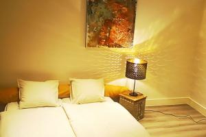 duas camas num quarto com um candeeiro sobre uma mesa em LodgeRivierenhof em Antuérpia