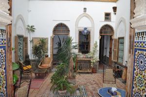 a courtyard of a house with plants and chairs at Riad Kasbah in Rabat