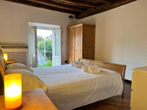 a bedroom with a large white bed and a window at Kibilù - Via Robarello - Sacro Monte in Varese