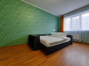 a bedroom with a bed and a green wall at ЕКО-квартира на Садововому. Мережа Alex Apartments. Цілодобове безконтактне заселення in Shcherbani