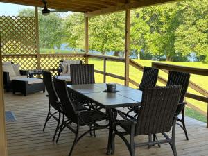 a table and chairs on a porch with a couch at Riverview Escape - Cabins on the Ohio River 