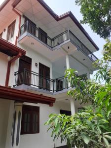 a white house with balconies on the side of it at VILLA GREEN VILLAGE in Kamburugamuwa