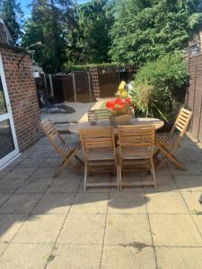a patio with a table and chairs and flowers at Cooks Spinney in Harlow