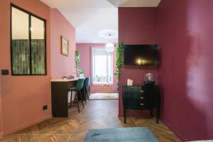 sala de estar con paredes rosas, mesa y sillas en Suite jacuzzi, chic romantique climatisé à 50 m du metro, en Villeurbanne