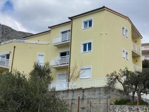 un edificio giallo con balconi bianchi sul lato di Kavajin Rooms a Duće