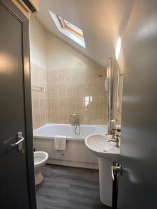 a bathroom with a tub and a sink and a toilet at Button Street by UStay Aparthotels in Liverpool