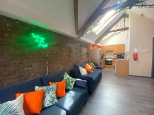 a living room with a blue couch and a brick wall at Button Street by UStay Aparthotels in Liverpool