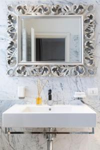 ein Badezimmer mit einem weißen Waschbecken und einem Spiegel in der Unterkunft Albergo Ristorante Il Verbano in Stresa