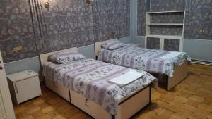 2 Betten in einem Zimmer mit lila Bettwäsche in der Unterkunft Royal Boutique Hotel on Kievyan in Yerevan