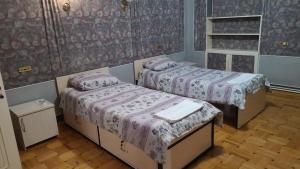 two beds in a room with purple sheets at Royal Boutique Hotel on Kievyan in Yerevan