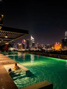 a person swimming in a swimming pool with a city skyline at METROPOLE -Central Saigon Riverside -Free POOL-GYM-SAUNA Room-YOGA Room in Ho Chi Minh City