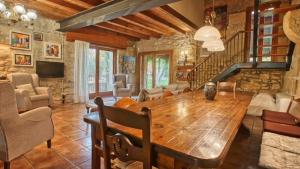 Casa Rural Lo molí في Juneda: غرفة معيشة مع طاولة خشبية وجدار حجري