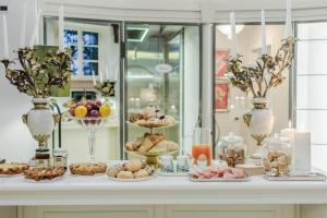 a table filled with different types of pastries and desserts at Lucca Heritage Retreat in Lucca