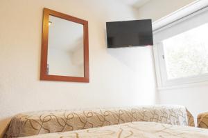 d'un miroir et d'un canapé dans une chambre avec fenêtre. dans l'établissement Hotel Traful, à Mar del Plata